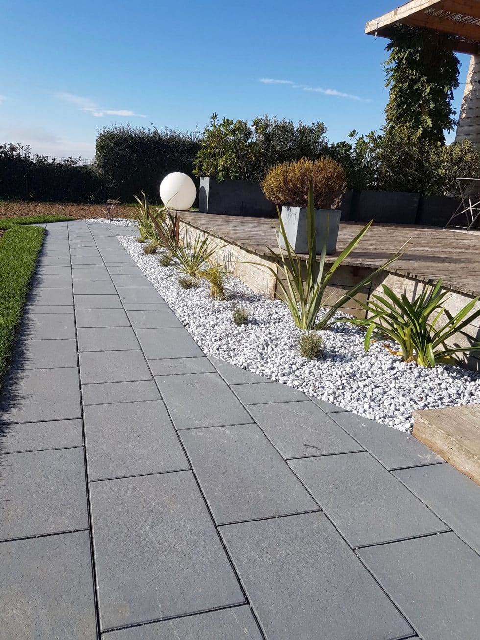 chemin pavé et massifs de graminées devant la terrasse bois Meximieux