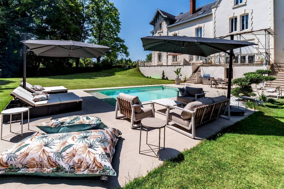 Espace piscine avec mobilier extérieur haut de gamme, grès cérame et végétation paysagée à Buellas, aux portes de Bourg-en-Bresse