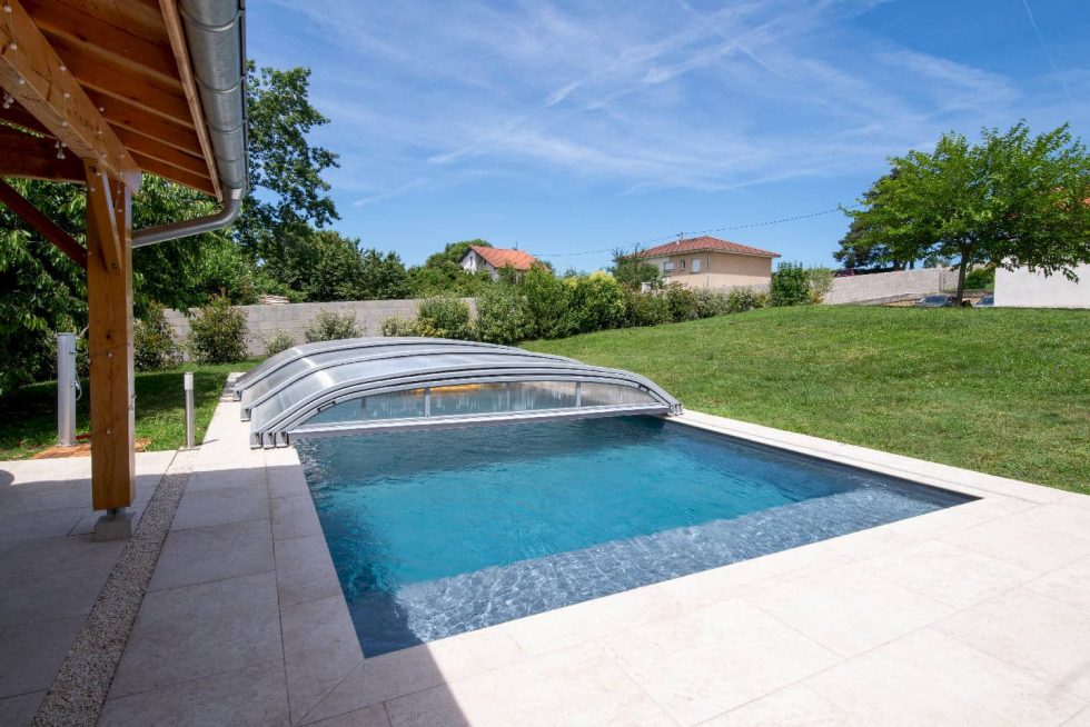 Abri fermé laissant entrevoir la ligne d’eau du bassin