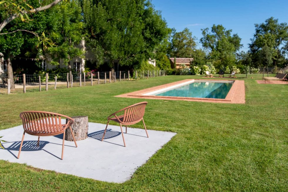 Espace de détente avec transats et aménagement paysager autour de la piscine