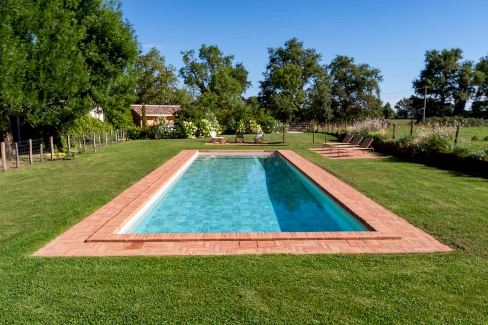 Piscine rectangulaire avec briques dans un environnement champêtre à Sandrans