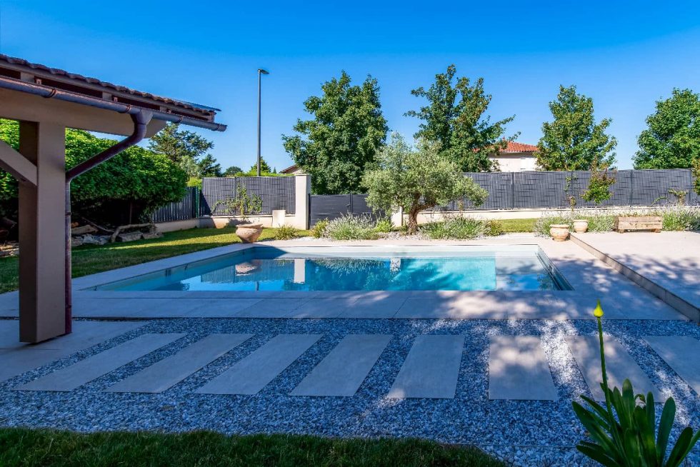 Terrasse couverte et vue sur la piscine en béton armé à Parcieux