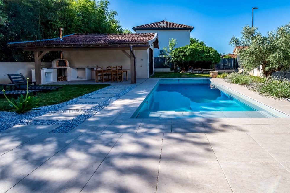 Piscine Mondial Piscine à Parcieux, margelles et ambiance minérale