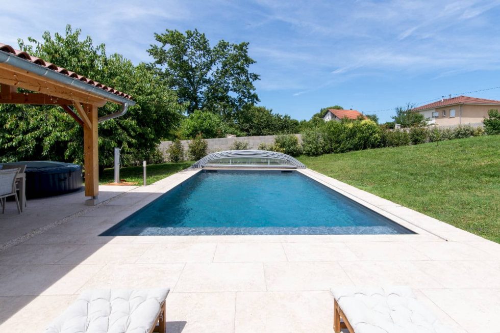 Perspective plongeante sur la piscine, soulignée par ses margelles claires